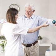 Physical Therapist working with patient holding weights