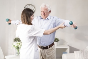 Physical Therapist working with patient holding weights