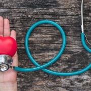 Hand holding heart shaped ball and stethoscope