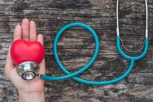 Hand holding heart shaped ball and stethoscope