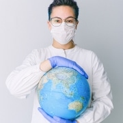 Medical professional holding a globe