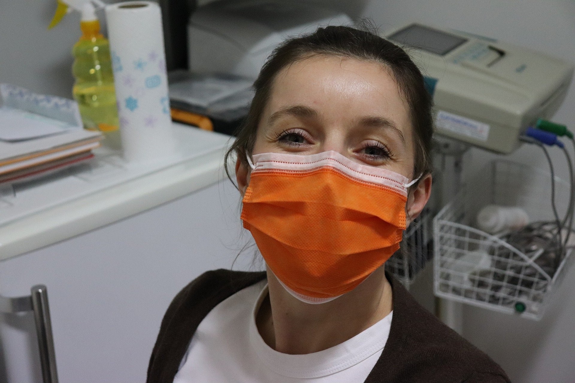 Smiling nurse in an orange mask