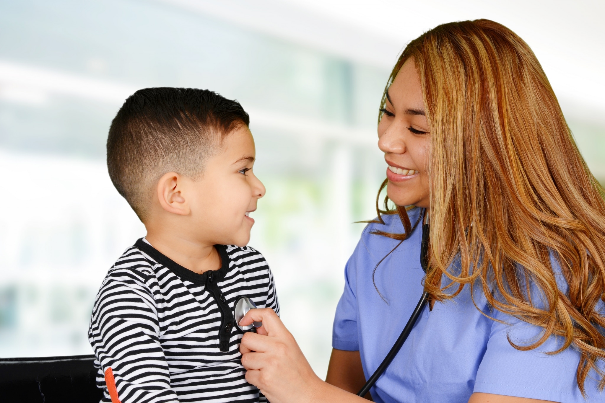 Female nurse listening to a child's heartbeat