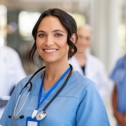 Smiling nurse with a team behind her