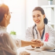 Healthcare professional holding the hand of an oncology patient