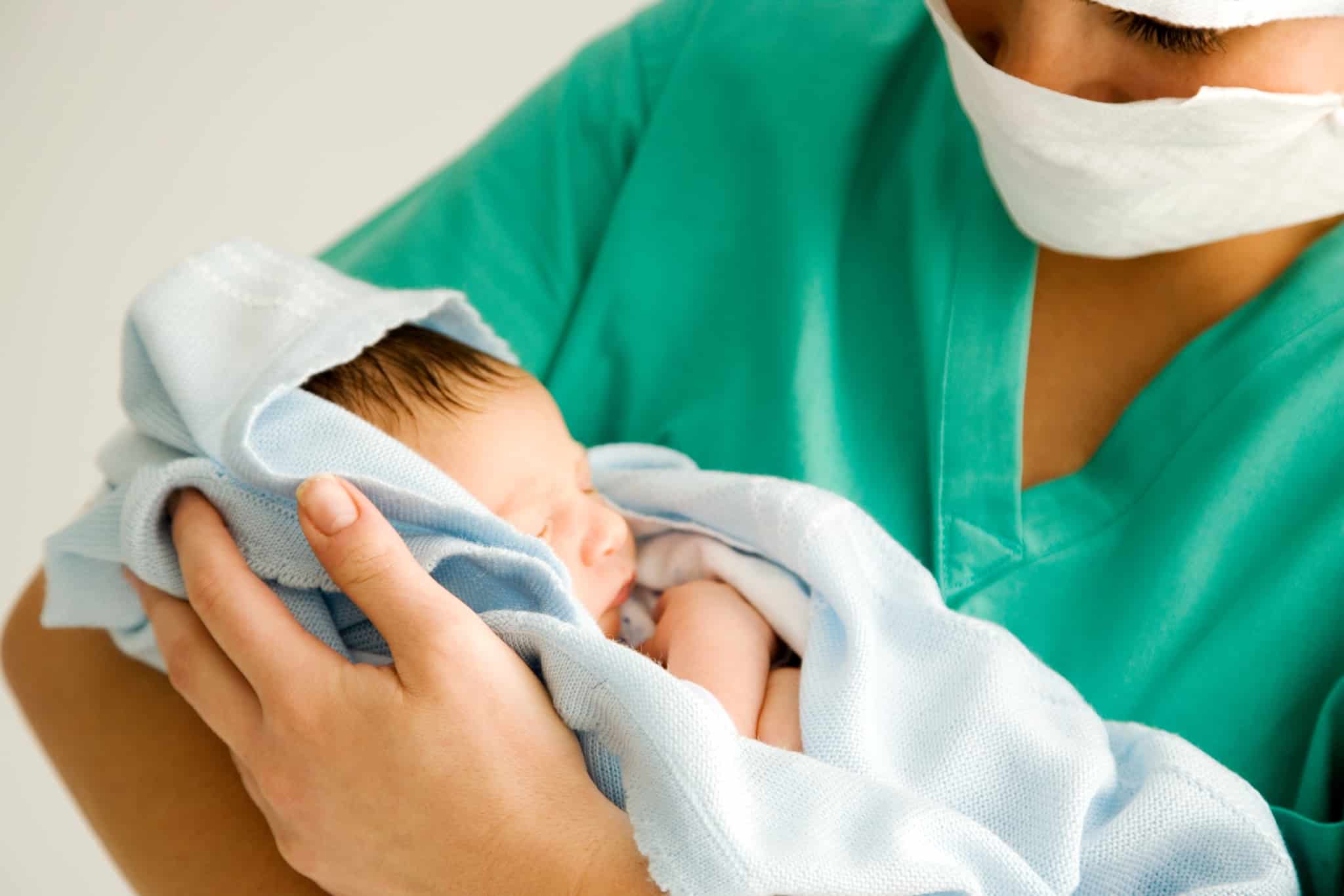 Maternity nurse holding a newborn baby
