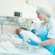 Young female nurse holding a newborn baby