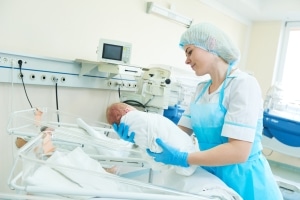 Young female nurse holding a newborn baby