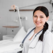 Nurse standing in front of a hospital bed