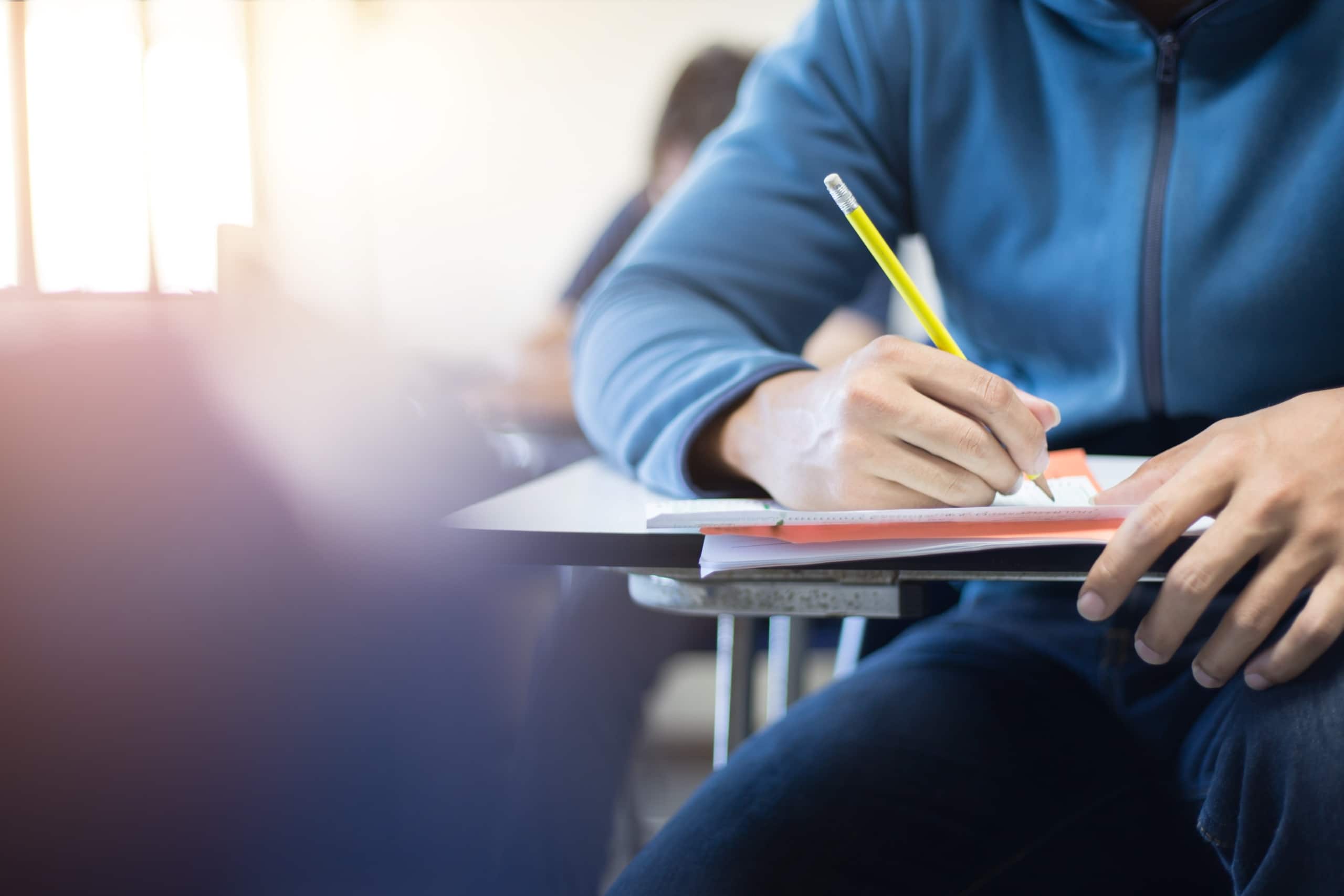 Close up of a student writing on an exam