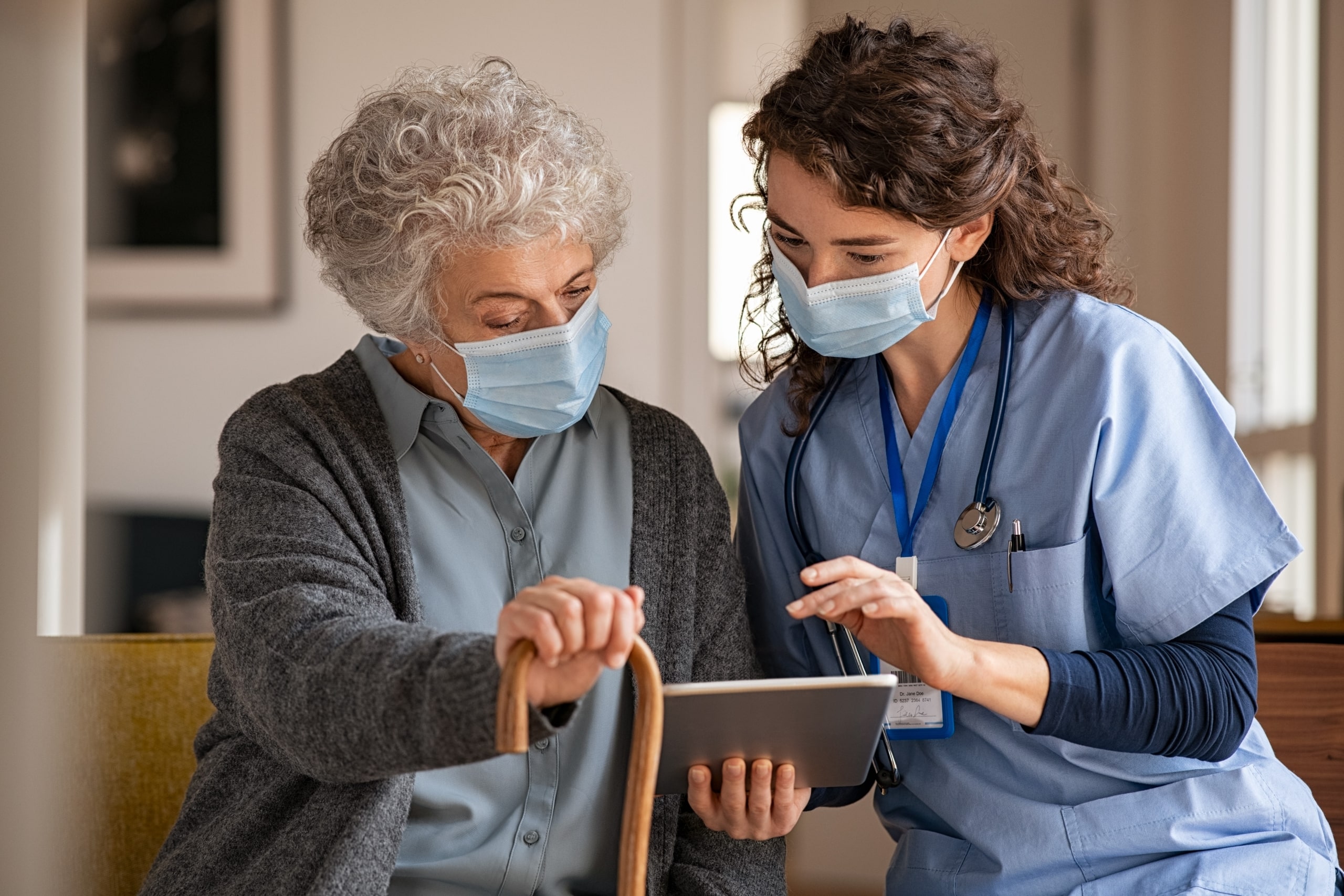 Medical professional and senior woman looking at tablet