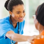 Caring African-American nurse with a patient