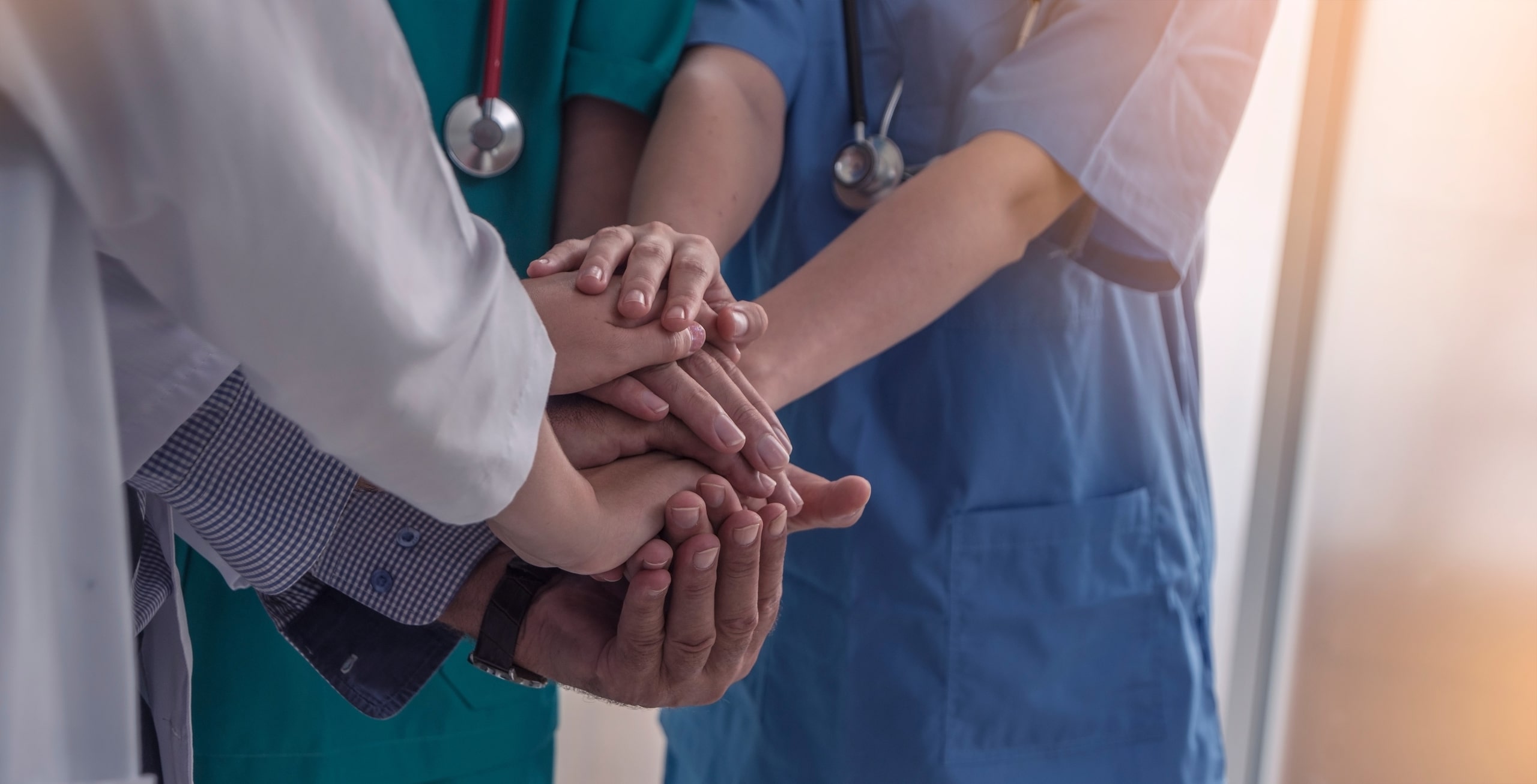 Close up of medial workers joining hands