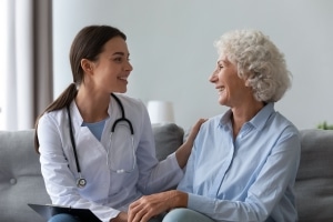 Happy young nurse with elderly patient