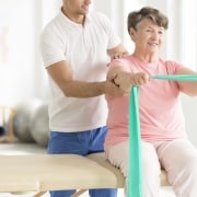 Elderly woman performing physical therapy exercises