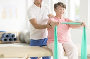 Elderly woman performing physical therapy exercises