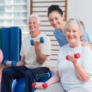 Elderly people using weights with a physical therapy professional